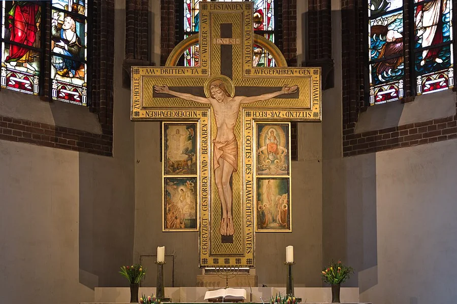 Crucifixo sobre o altar de uma igreja, entre vitrais