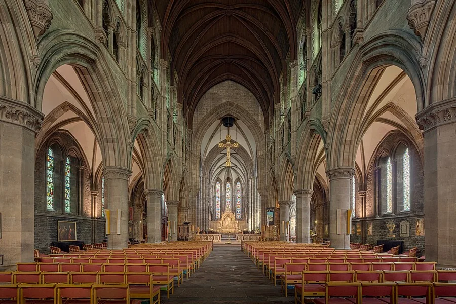 Nave central de uma catedral com arcos e bancos